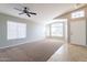 Bright living room featuring plush carpet, large windows, and a ceiling fan at 3522 E Edna Ave, Phoenix, AZ 85032