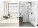 Modern bathroom with a soaking tub, glass block window, and tiled shower at 35306 N 31St Dr, Phoenix, AZ 85086