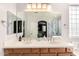 Well-lit bathroom with double sinks, wood cabinets, and large mirror at 35306 N 31St Dr, Phoenix, AZ 85086