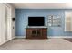 Comfortable living room features a TV, media center, and natural light from white shuttered window at 35306 N 31St Dr, Phoenix, AZ 85086