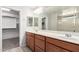 Bathroom features a dual sink vanity with wooden cabinets, a large mirror, and recessed lighting at 3532 E Alfalfa Dr, Gilbert, AZ 85298