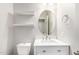 Stylish powder room featuring a modern vanity, oval mirror, and floating shelves at 3532 E Alfalfa Dr, Gilbert, AZ 85298