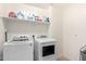 Bright laundry room with newer washer and dryer with a shelf above at 3532 E Alfalfa Dr, Gilbert, AZ 85298