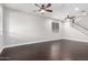 Open living room with dark wood-look floors, a staircase, and modern ceiling fans at 3532 E Alfalfa Dr, Gilbert, AZ 85298