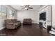 Cozy living room with hardwood floors, ceiling fan, and a built-in entertainment center at 3532 E Alfalfa Dr, Gilbert, AZ 85298