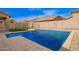 Backyard pool with cool, clear water, block wall, fenced grass and bordering houses in the distance at 3532 E Alfalfa Dr, Gilbert, AZ 85298