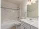 Bathroom featuring shower-tub combo with white marble tile, white vanity, and decorative mirror at 3635 W Cortez St, Phoenix, AZ 85029