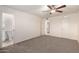 A carpeted bedroom with ceiling fan, bathroom access, and a double door closet at 3635 W Cortez St, Phoenix, AZ 85029