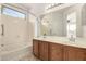 A well-lit bathroom featuring double sinks and a tub with shower at 37808 N Pagoda Ln, Phoenix, AZ 85086