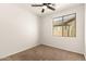 This bedroom features neutral carpet, a ceiling fan, and a window for ample natural light at 37808 N Pagoda Ln, Phoenix, AZ 85086