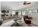 Bright living room with neutral-toned sofa, ceiling fan, and sliding doors leading to the backyard patio at 3781 S Pablo Pass Dr, Gilbert, AZ 85297