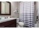 Compact bathroom featuring a vanity sink and a shower with a gray and white striped curtain at 3793 E Canyon Pl, Chandler, AZ 85249