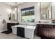 Bright bathroom featuring a soaking tub, a window, and a dark vanity with a white countertop, offering a relaxing space at 3793 E Canyon Pl, Chandler, AZ 85249