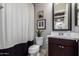 Cozy bathroom with a black and white patterned shower curtain and a dark wood vanity at 3793 E Canyon Pl, Chandler, AZ 85249