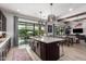 Kitchen features a large island with sink, pendant lighting, and seamless flow into the living room and patio at 3793 E Canyon Pl, Chandler, AZ 85249