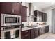 A close-up view of the kitchen, showcasing the oven, microwave, gas cooktop, and dark wood cabinets at 3793 E Canyon Pl, Chandler, AZ 85249