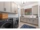 Well-lit laundry room featuring gray cabinets, a front-load washer and dryer, and a decorative rug at 3793 E Canyon Pl, Chandler, AZ 85249