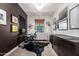 Stylish home office featuring a modern glass desk, chandelier lighting, and dark accent wall at 3793 E Canyon Pl, Chandler, AZ 85249