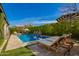 Beautiful pool and backyard with stone waterfalls, tanning deck, umbrellas, and lounge seating at 3793 E Canyon Pl, Chandler, AZ 85249