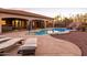 Scenic backyard with a pristine pool, multiple seating areas, desert landscaping, and a rock waterfall feature at 39610 N 12Th St, Phoenix, AZ 85086