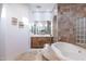 Luxurious soaking tub with tile surround and glass block window, and and vanity at 39610 N 12Th St, Phoenix, AZ 85086