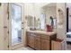 Bathroom with a light brown vanity, a large mirror, and a door to the exterior at 39610 N 12Th St, Phoenix, AZ 85086