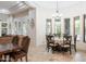 Bright dining room with travertine floors, two dining tables, and a view of the outdoor living area at 39610 N 12Th St, Phoenix, AZ 85086