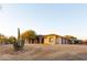 Expansive desert landscape with a stucco home featuring an attached pergola and spacious three-car garage at 39610 N 12Th St, Phoenix, AZ 85086