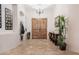 Welcoming foyer boasting double doors, travertine tile flooring, and a statement table at 39610 N 12Th St, Phoenix, AZ 85086