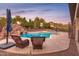 Inviting backyard pool with rock waterfall feature, landscaping, lounge chairs, and scenic desert views at 39610 N 12Th St, Phoenix, AZ 85086