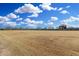 Expansive open field, ideal for recreation or development with clear blue skies and scattered clouds at 42 E 14Th St, Mesa, AZ 85201