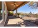 Relaxing covered patio area with desert landscape, a metal fence, and mountain views in the distance at 42829 N Livingstone Way, Anthem, AZ 85086