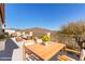 Balcony showcasing outdoor seating, a dining table, yellow flowers, and desert mountain views at 42829 N Livingstone Way, Anthem, AZ 85086