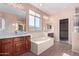 Bright bathroom featuring double sinks, a tub, a separate shower, and dark wood cabinetry at 42829 N Livingstone Way, Anthem, AZ 85086