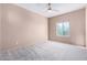 Neutral bedroom featuring carpet floors, a ceiling fan, and a bright window at 42829 N Livingstone Way, Anthem, AZ 85086