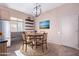 Virtual staging showcases a dining area with table, rug, and seaside painting at 42829 N Livingstone Way, Anthem, AZ 85086