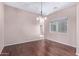 Empty dining room featuring hardwood floors, neutral paint, and a modern light fixture at 42829 N Livingstone Way, Anthem, AZ 85086