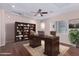 Virtual staging showcases a functional home office with desk, bookshelves, and rug at 42829 N Livingstone Way, Anthem, AZ 85086