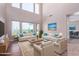 Bright living room with neutral paint, and a pair of white couches facing a coffee table at 42829 N Livingstone Way, Anthem, AZ 85086