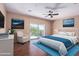 Bright main bedroom with a sliding glass door to a balcony, wood floors, and a ceiling fan at 42829 N Livingstone Way, Anthem, AZ 85086