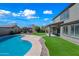 Attractive backyard featuring a pool, pergola, and well-manicured lawn, creating an inviting outdoor space at 43819 W Wolf Dr, Maricopa, AZ 85138