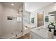 Elegant bathroom featuring a glass-enclosed shower, soaking tub, and modern vanity with stylish fixtures at 43819 W Wolf Dr, Maricopa, AZ 85138