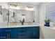 Stylish blue bathroom vanity featuring double sinks and a bright window at 43819 W Wolf Dr, Maricopa, AZ 85138