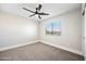 Comfortable bedroom with carpet, a fan, and a window overlooking the neighborhood at 43819 W Wolf Dr, Maricopa, AZ 85138