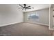 Large bedroom featuring a ceiling fan, carpeted floors, and a bright sunny window at 43819 W Wolf Dr, Maricopa, AZ 85138