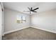 Bedroom with neutral walls, ceiling fan, plush carpet, and a window offering natural light at 43819 W Wolf Dr, Maricopa, AZ 85138