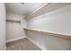 Walk-in closet with carpeted floors and white shelving units perfect for storage at 43819 W Wolf Dr, Maricopa, AZ 85138