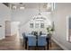 Bright dining area with hardwood floors, modern lighting, and an open staircase at 43819 W Wolf Dr, Maricopa, AZ 85138