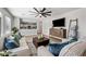 Inviting living room with plush seating, modern decor, and seamless flow into the kitchen at 43819 W Wolf Dr, Maricopa, AZ 85138