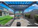 Stylish pergola providing shade over a tiled patio, with a view of the manicured lawn and inviting backyard pool at 43819 W Wolf Dr, Maricopa, AZ 85138